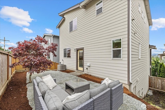 rear view of house with a fenced backyard, an outdoor living space, central AC, and a patio area
