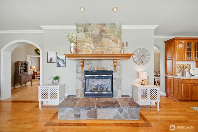 2961 Kendall Rd, Walla Walla, WA 99362 - living area with arched walkways, ornamental molding, light wood-style flooring, a stone fireplace, and baseboards