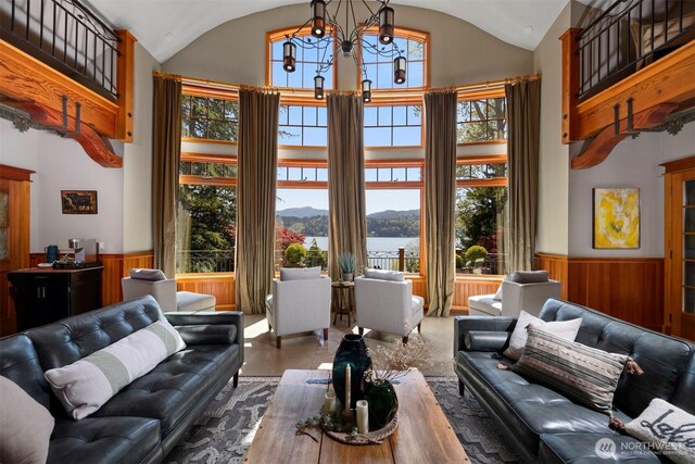 2141 Northshore Rd, Bellingham, WA 98226 - living room with a water and mountain view, high vaulted ceiling, an inviting chandelier, and a wainscoted wall