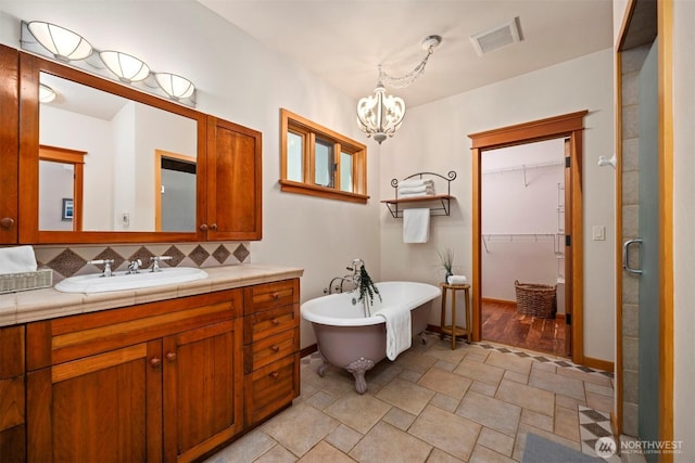 2141 Northshore Rd, Bellingham, WA 98226 - bathroom featuring a notable chandelier, a freestanding bath, visible vents, tasteful backsplash, and a spacious closet