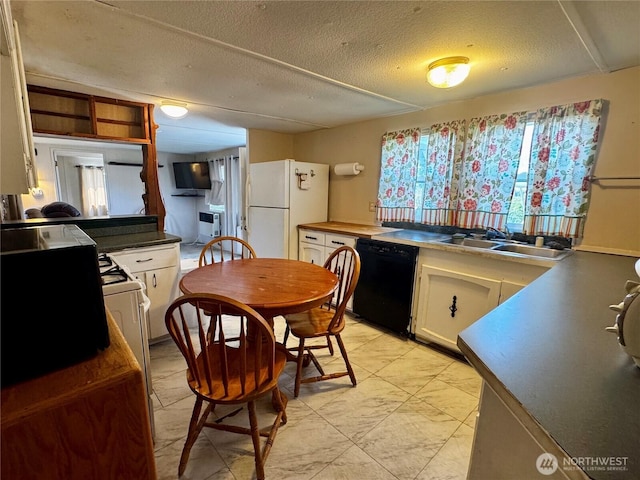 kitchen featuring freestanding refrigerator, a textured ceiling, white cabinets, a sink, and dishwasher