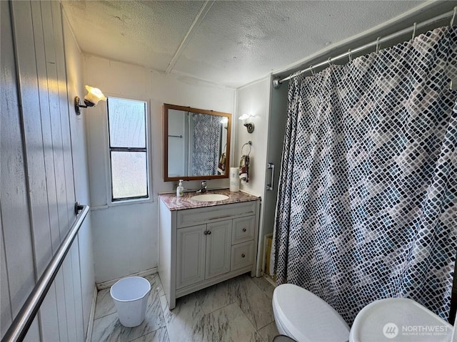 bathroom featuring vanity, marble finish floor, curtained shower, toilet, and a textured ceiling
