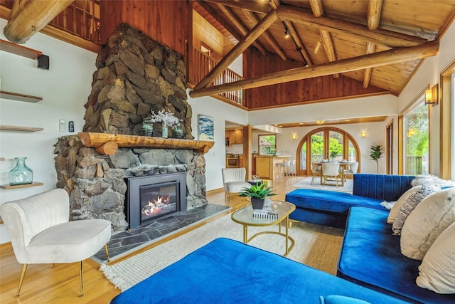 living room with a stone fireplace, wood finished floors, wooden ceiling, high vaulted ceiling, and beamed ceiling