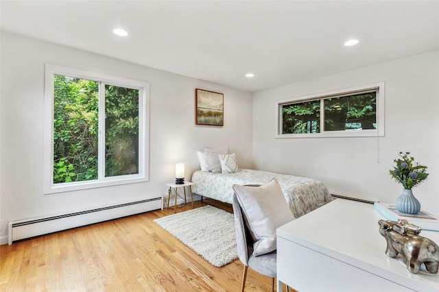 bedroom featuring wood finished floors, recessed lighting, and a baseboard heating unit
