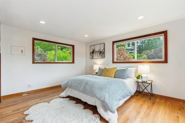 bedroom with recessed lighting, baseboards, multiple windows, and light wood-type flooring