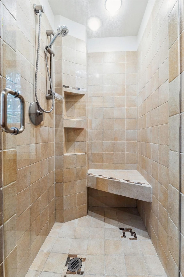 full bathroom featuring tile patterned flooring and a shower stall