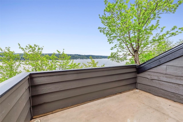 view of patio with a water view and a balcony