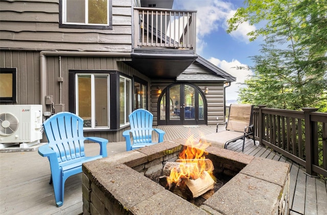 wooden deck featuring ac unit and an outdoor fire pit