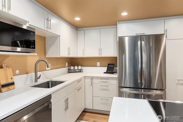 2320 43rd Ave E Unit 15A, Seattle, WA 98112 - kitchen featuring appliances with stainless steel finishes, a sink, light countertops, recessed lighting, and white cabinetry