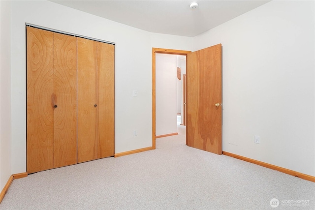 unfurnished bedroom with carpet floors, baseboards, and a closet