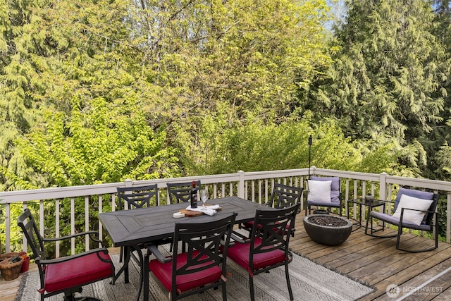 8957 Watson Pl NE, Bremerton, WA 98311 - wooden deck featuring outdoor dining area and a view of trees