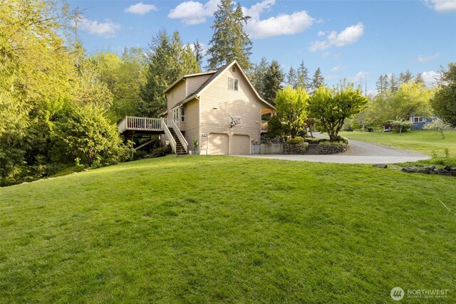 8957 Watson Pl NE, Bremerton, WA 98311 - view of home's exterior featuring a garage, a deck, a lawn, driveway, and stairs