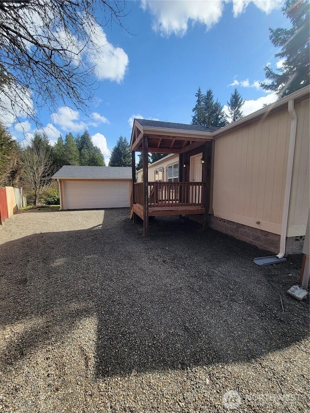 view of side of home featuring an outdoor structure, driveway, crawl space, and a deck