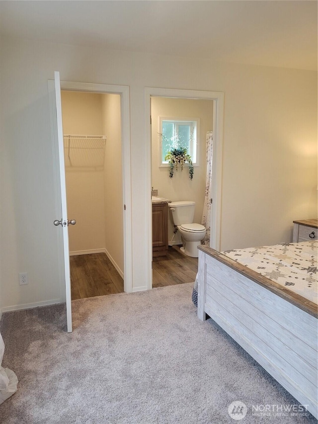 bedroom featuring ensuite bath, carpet, baseboards, a spacious closet, and a closet
