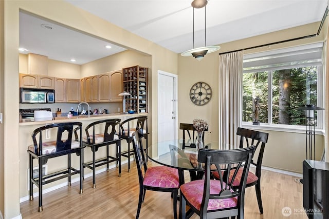 dining room with recessed lighting, baseboards, and light wood-type flooring