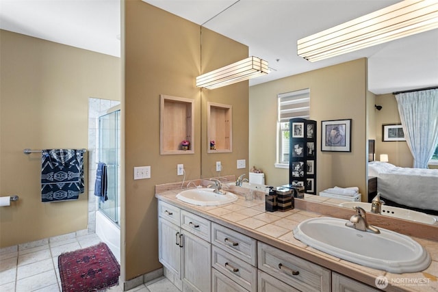 full bath featuring double vanity, a sink, combined bath / shower with glass door, and tile patterned flooring