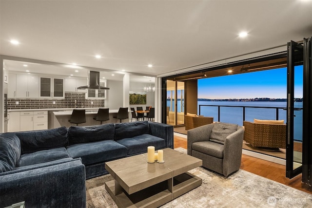 807 Lake St S Unit 300, Kirkland, WA 98033 - living area with light wood-type flooring, floor to ceiling windows, a water view, and a chandelier