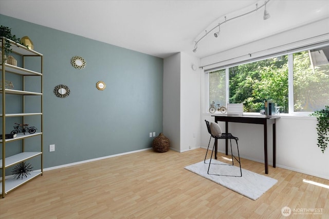 sitting room with track lighting, baseboards, and wood finished floors