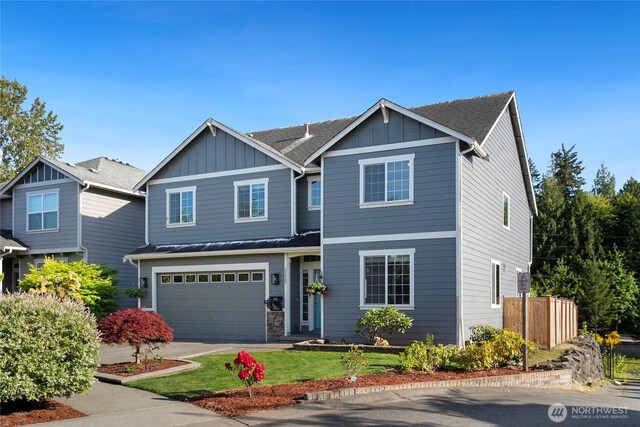 view of front facade with board and batten siding, an attached garage, concrete driveway, and roof with shingles