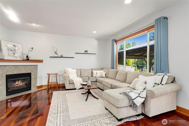 living room with wood finished floors, recessed lighting, a fireplace, and baseboards