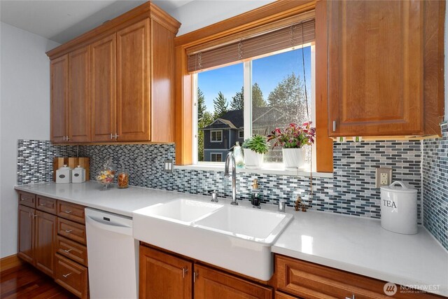 kitchen with dishwasher, a sink, and tasteful backsplash