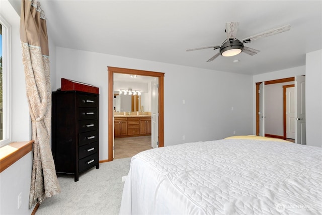 bedroom with light colored carpet, connected bathroom, and ceiling fan