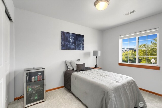 bedroom featuring baseboards, carpet flooring, and beverage cooler