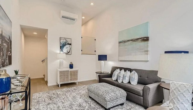 living room with an AC wall unit, recessed lighting, baseboards, and wood finished floors