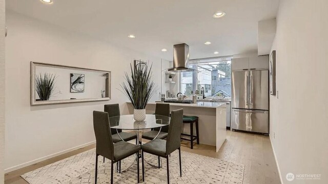dining room with recessed lighting, baseboards, and light wood finished floors