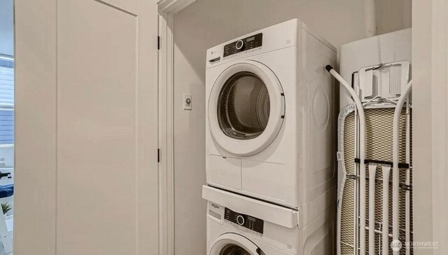 clothes washing area featuring stacked washer / drying machine and laundry area