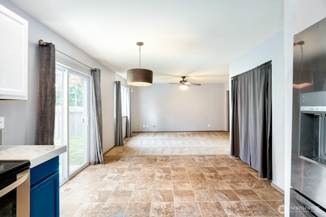 kitchen featuring stone finish floor, ceiling fan, blue cabinets, light countertops, and stainless steel appliances