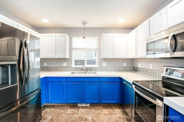 kitchen with stainless steel appliances, blue cabinetry, a healthy amount of sunlight, and a sink