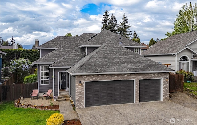 1618 Hoquiam Pl NE, Renton, WA 98059 - traditional-style home featuring an attached garage, fence, concrete driveway, roof with shingles, and brick siding