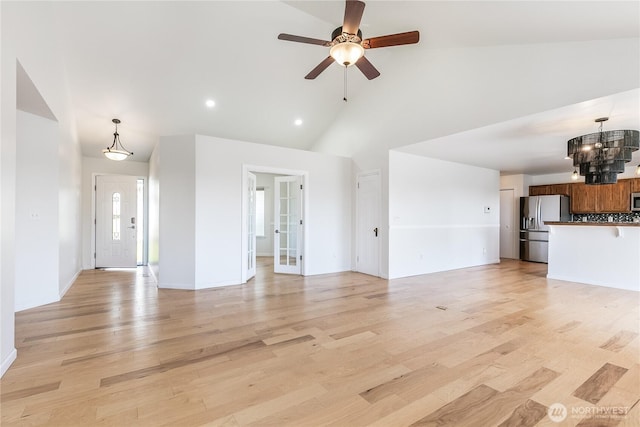5208 Tumac Dr, Yakima, WA 98901 - unfurnished living room featuring light wood-style floors, high vaulted ceiling, ceiling fan with notable chandelier, recessed lighting, and baseboards