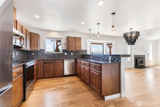 5208 Tumac Dr, Yakima, WA 98901 - kitchen with stainless steel appliances, light wood-style floors, tasteful backsplash, and a peninsula