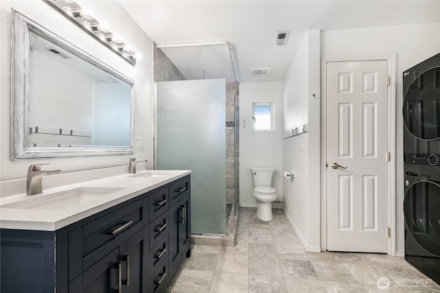 5208 Tumac Dr, Yakima, WA 98901 - full bath with double vanity, a sink, a tile shower, and stacked washer / dryer