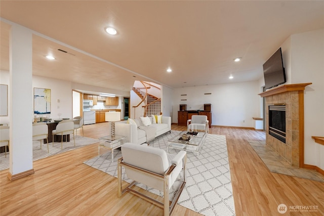6714 89th Street Ct E, Puyallup, WA 98371 - living area with stairway, light wood-type flooring, a fireplace, baseboards, and recessed lighting