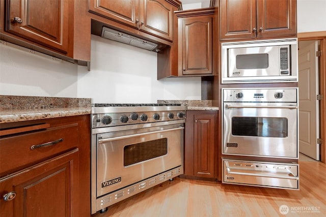 6714 89th Street Ct E, Puyallup, WA 98371 - kitchen featuring stainless steel appliances, a warming drawer, under cabinet range hood, and light stone counters