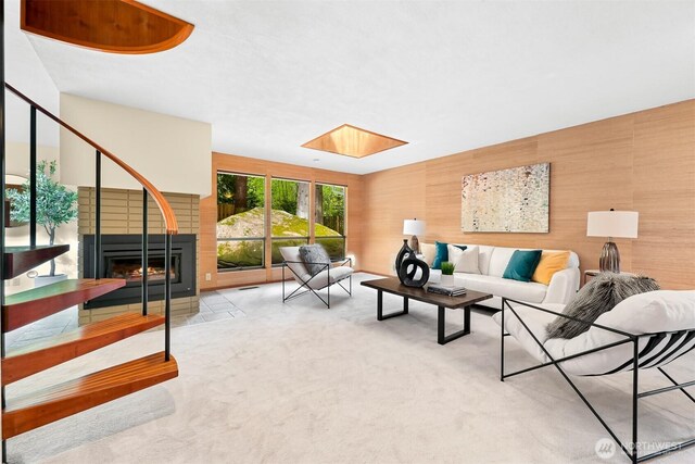 carpeted living area featuring a multi sided fireplace and a skylight
