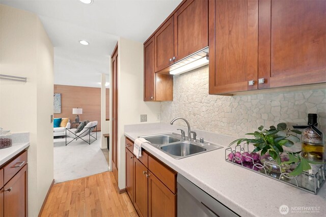 kitchen featuring a sink, light wood finished floors, light countertops, recessed lighting, and tasteful backsplash
