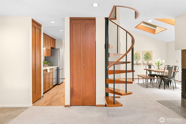 stairway featuring a skylight, baseboards, carpet flooring, and recessed lighting