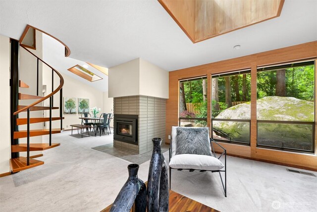 living area with plenty of natural light, lofted ceiling, visible vents, and stairway