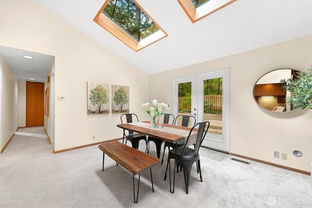 dining area featuring french doors, light colored carpet, a skylight, visible vents, and baseboards