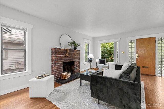 living area featuring baseboards, wood finished floors, and a fireplace