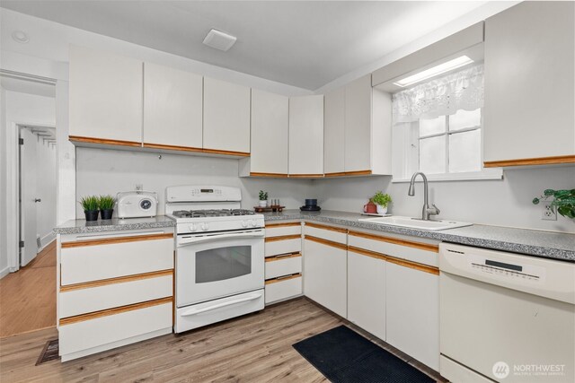kitchen featuring light wood-type flooring, a sink, white cabinets, and white appliances