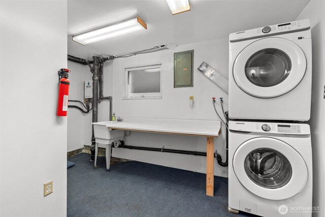 clothes washing area with carpet, electric panel, stacked washer / dryer, and laundry area