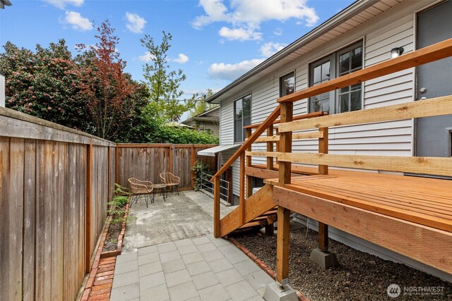 wooden terrace with a fenced backyard and a patio area