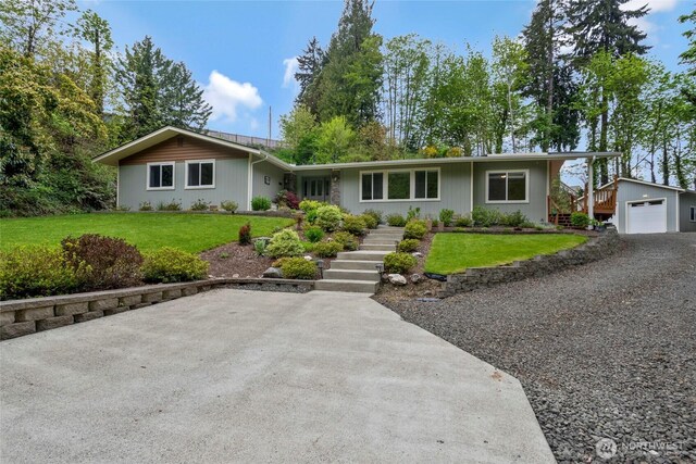 single story home with a garage, an outbuilding, stairs, and a front yard