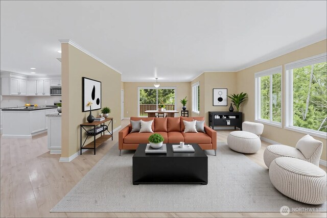 living area featuring recessed lighting, baseboards, crown molding, and light wood finished floors
