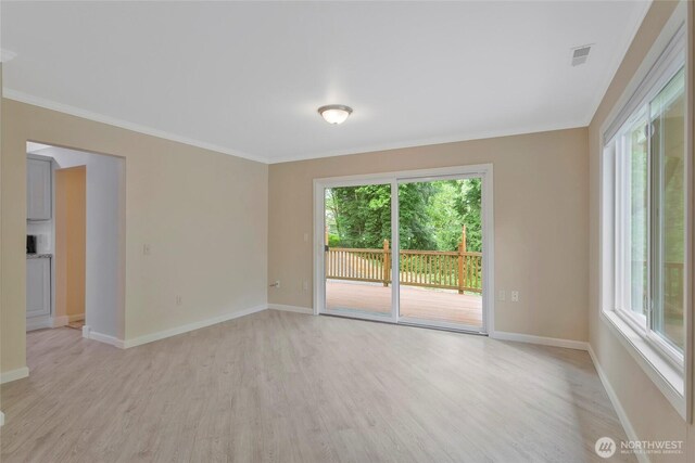 empty room featuring baseboards, visible vents, and light wood-type flooring